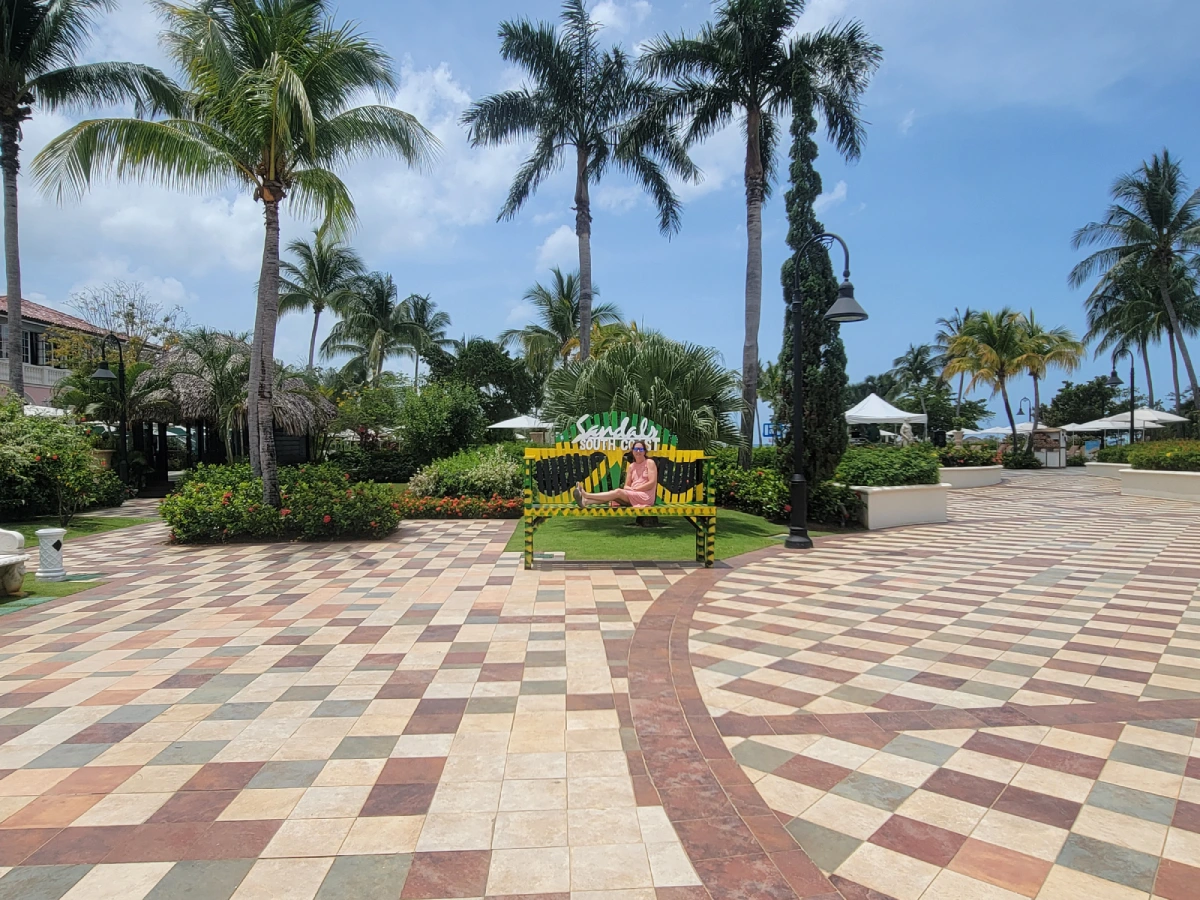 A large paved area with palm trees and benches.